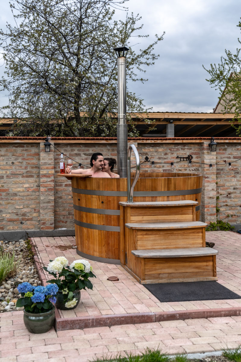Outdoor wellness facility with a large wooden hot tub